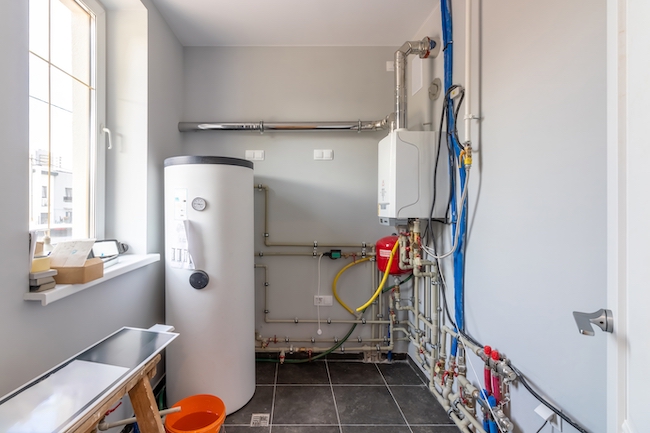 Do you need an electrician or a plumber for hot water system repairs?